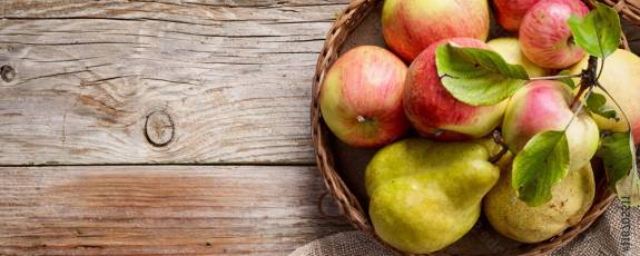 Korb mit Äpfeln auf einem Holztisch