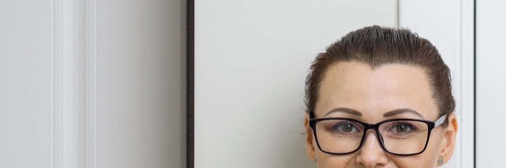 Putzfrau leht selbstbewusst an einer Tür