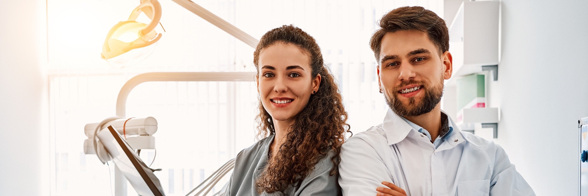 Zahnarzt und Assistentin stehen als Team im Behandlungszimmer